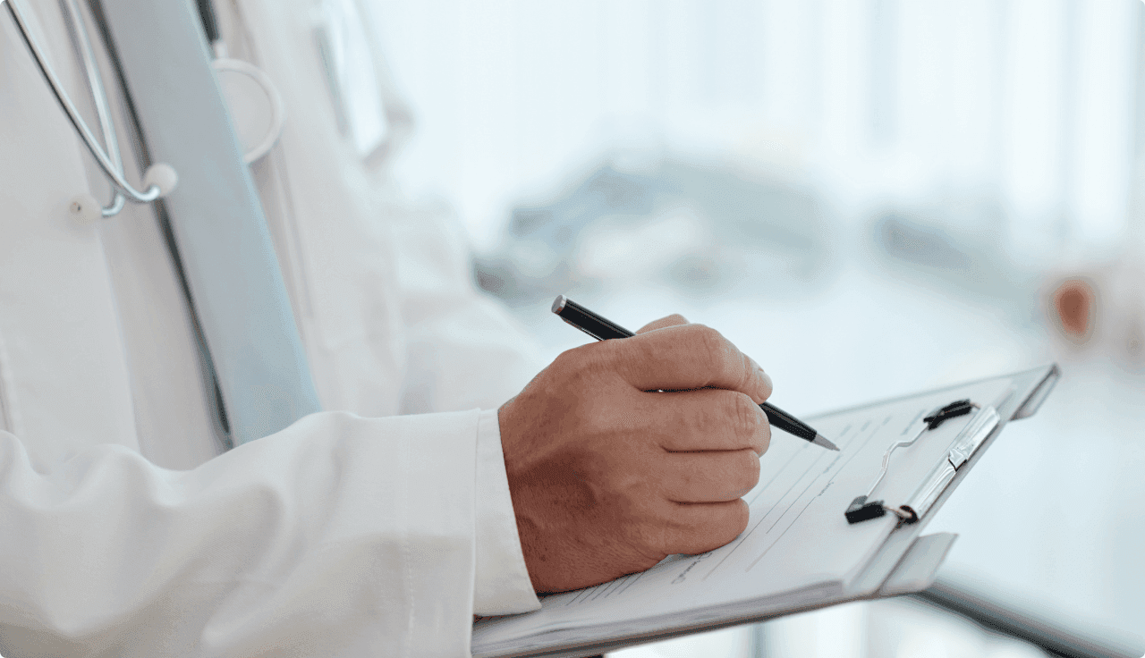 Arzt schreibt etwas auf ein Klemmbrett